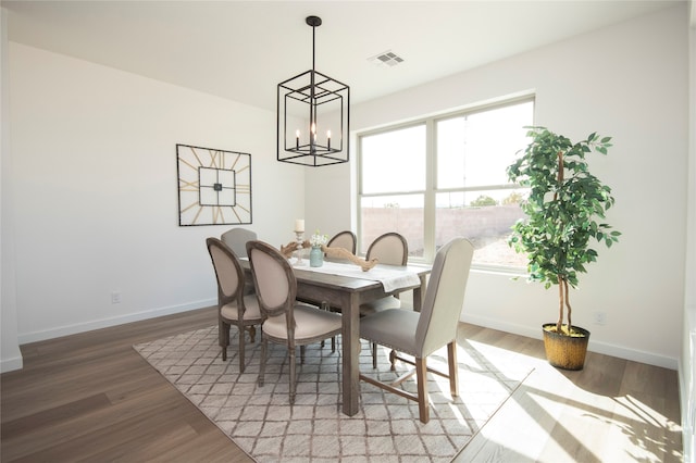 dining space with light hardwood / wood-style flooring and an inviting chandelier