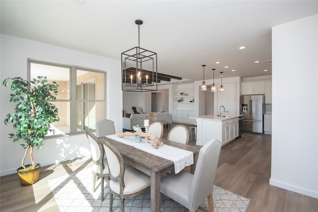 dining space with a chandelier, hardwood / wood-style floors, and sink