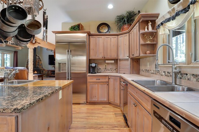 kitchen featuring pendant lighting, appliances with stainless steel finishes, a chandelier, a breakfast bar, and light hardwood / wood-style floors