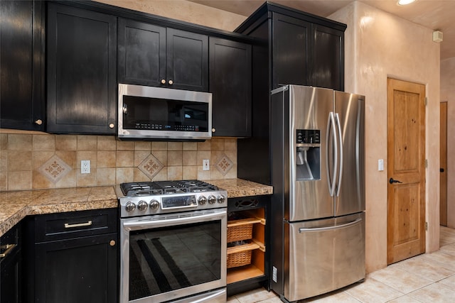 kitchen featuring tasteful backsplash, light tile patterned floors, and appliances with stainless steel finishes