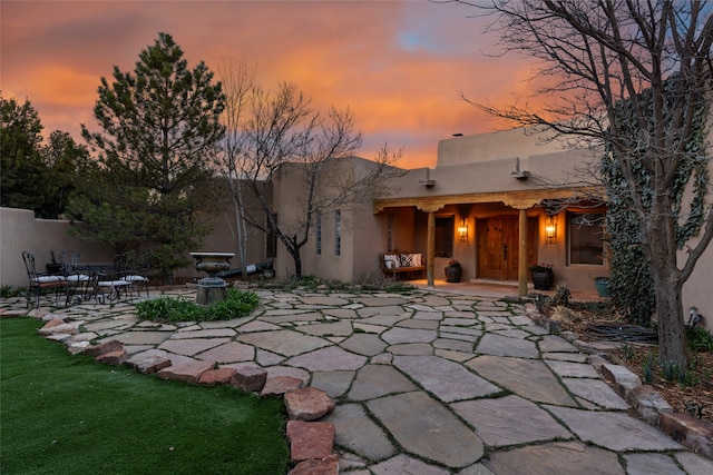 back house at dusk with a patio