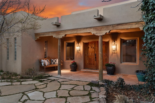 exterior entry at dusk featuring a patio area