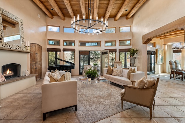 living room featuring a towering ceiling, a chandelier, light tile patterned floors, wooden ceiling, and beam ceiling