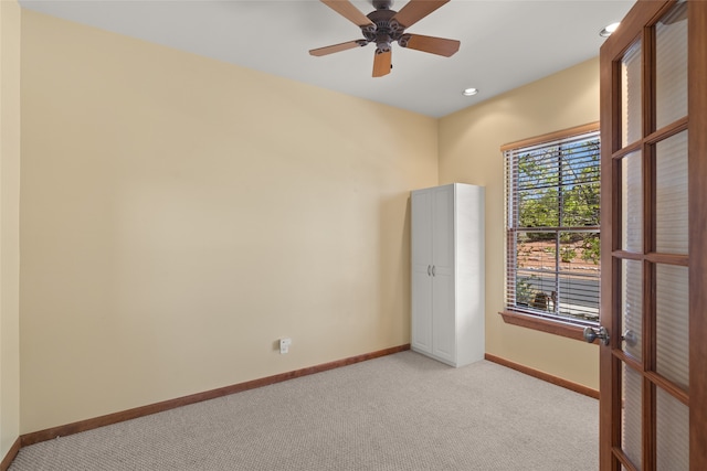 carpeted empty room featuring ceiling fan