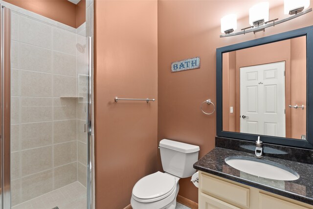 bathroom featuring walk in shower, vanity, and toilet