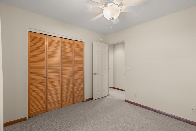 unfurnished bedroom with a closet, ceiling fan, and light colored carpet