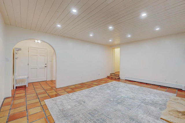 tiled empty room with baseboard heating and wooden ceiling