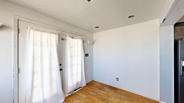 unfurnished room featuring wood-type flooring and a textured ceiling