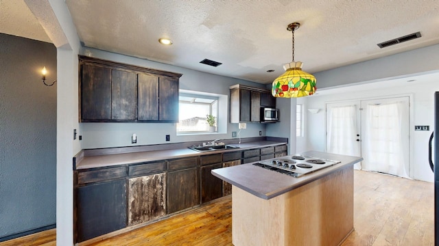 kitchen featuring sink, light hardwood / wood-style floors, a center island, and white electric stovetop