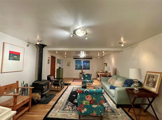 living room with a wood stove and light hardwood / wood-style flooring