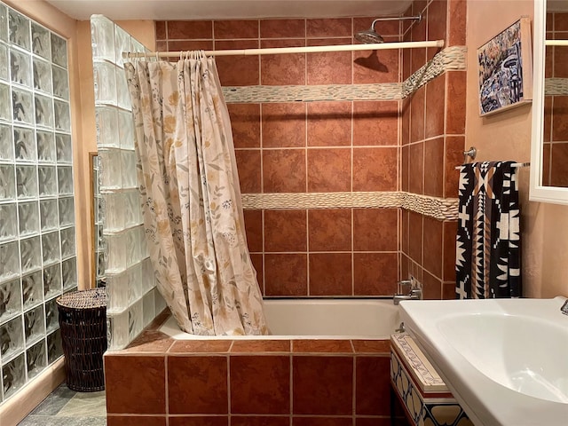 bathroom featuring shower / bathtub combination with curtain and sink