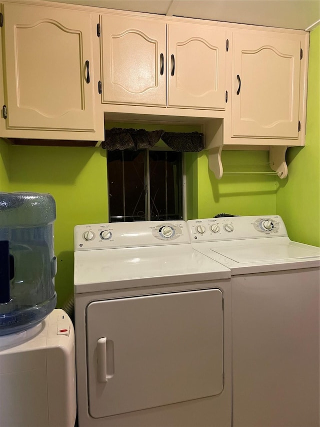 clothes washing area featuring cabinets and washing machine and dryer