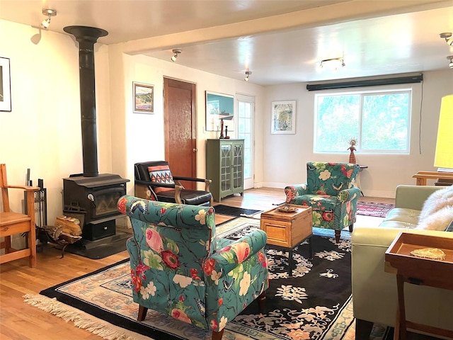 living room with light hardwood / wood-style floors and a wood stove