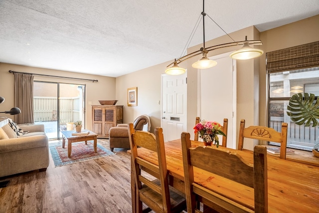 dining space with a textured ceiling and wood-type flooring