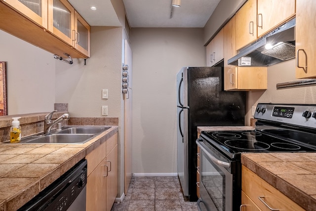 kitchen featuring appliances with stainless steel finishes, sink, light tile floors, and tile counters