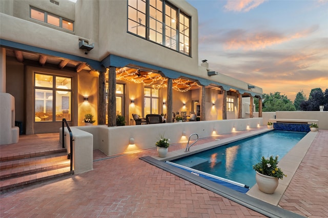 pool at dusk with a patio