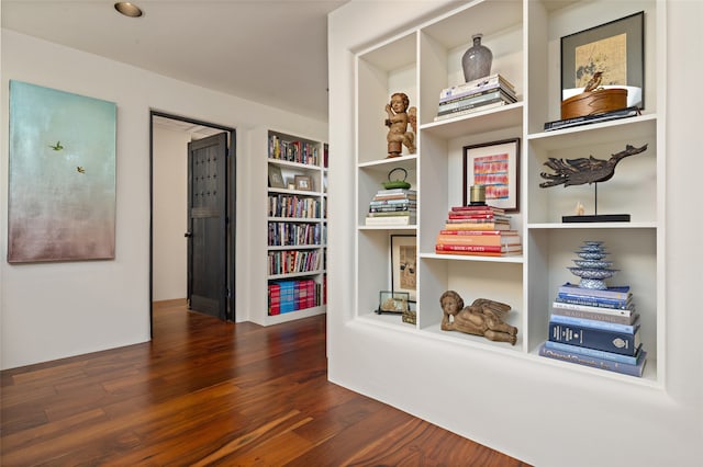 hall with built in features and dark hardwood / wood-style floors