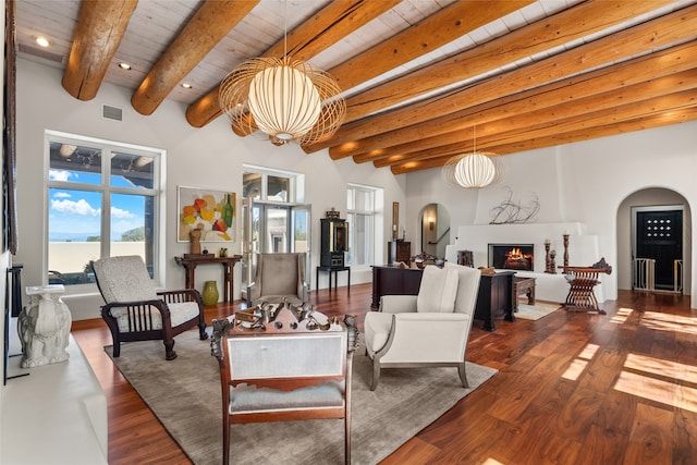 living room featuring wood ceiling, dark wood-type flooring, a large fireplace, and beamed ceiling