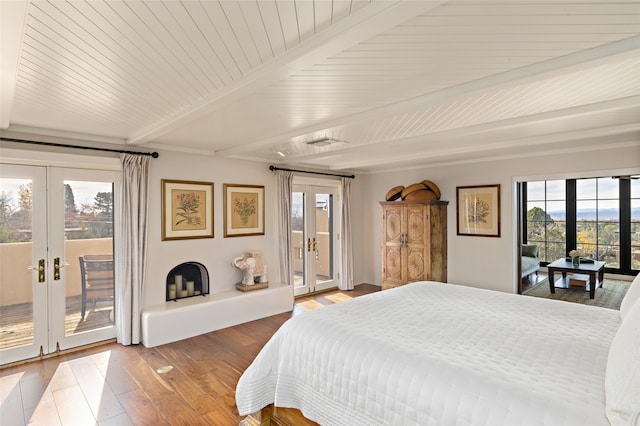 bedroom with access to outside, beam ceiling, french doors, and wood-type flooring