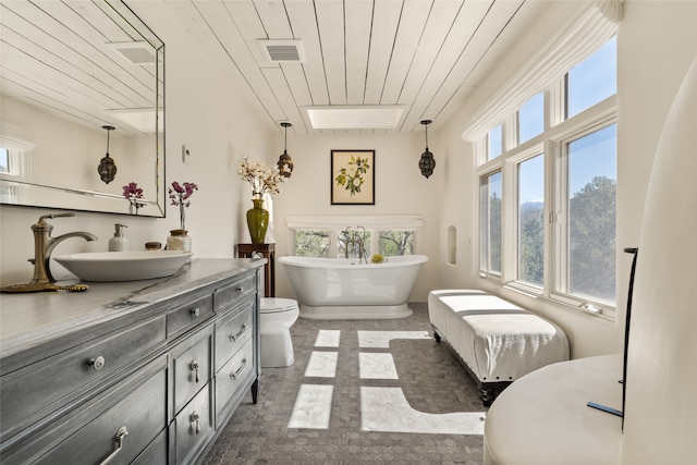 bathroom featuring a bath, wooden ceiling, toilet, and vanity