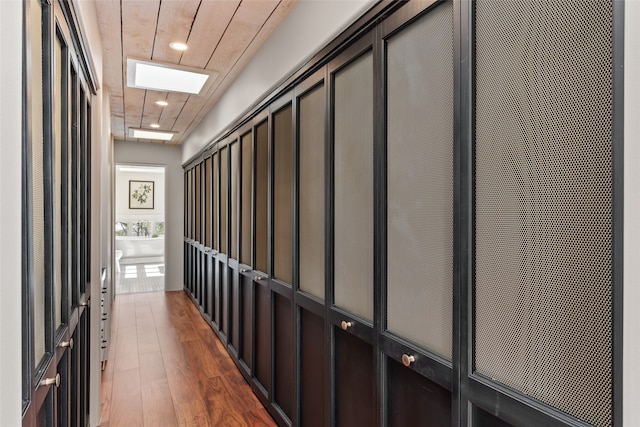 corridor with dark wood-type flooring and wooden ceiling