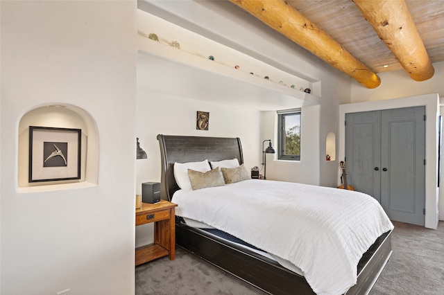 bedroom with beam ceiling and carpet floors