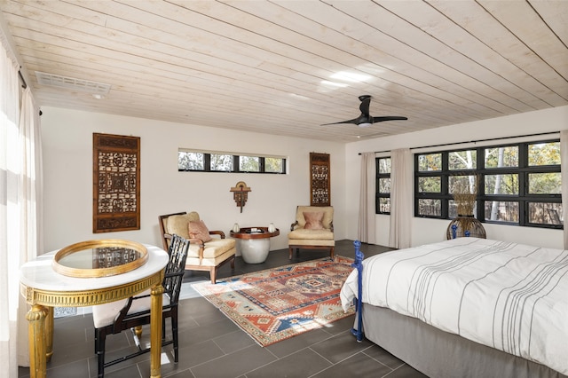 bedroom featuring ceiling fan, wood ceiling, dark tile patterned floors, and multiple windows