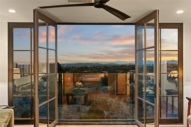 doorway to outside with a mountain view, floor to ceiling windows, and ceiling fan