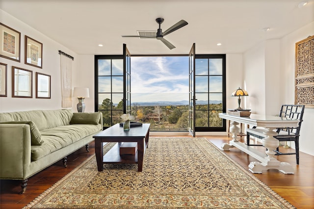 living room featuring ceiling fan, wood-type flooring, and expansive windows