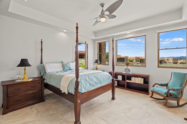 bedroom with a tray ceiling and ceiling fan