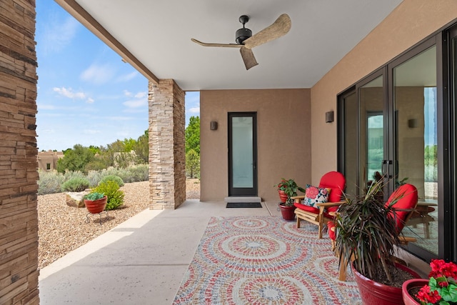 entrance to property with a patio area, stucco siding, and ceiling fan