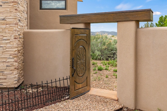 property entrance with fence and stucco siding