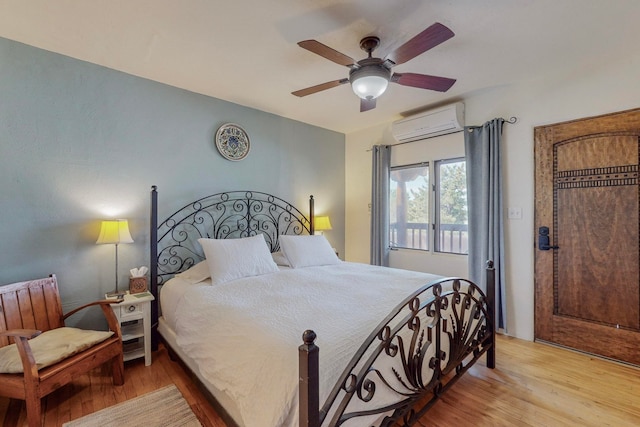 bedroom with a wall unit AC, ceiling fan, and light hardwood / wood-style floors