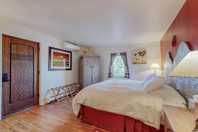 bedroom with a wall unit AC, a baseboard radiator, and light wood-type flooring