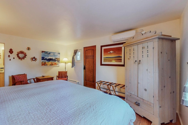 bedroom featuring a baseboard heating unit, hardwood / wood-style flooring, and a wall unit AC