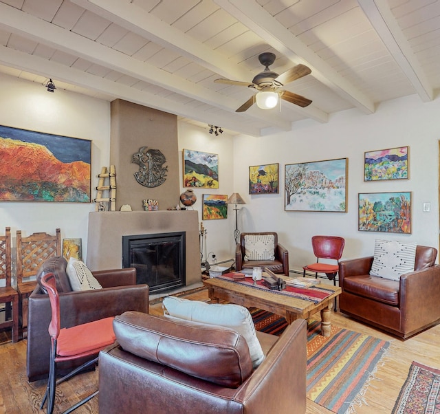 living room with wood-type flooring, ceiling fan, and beam ceiling