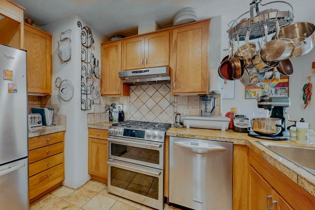 kitchen with stainless steel appliances, light tile flooring, and backsplash