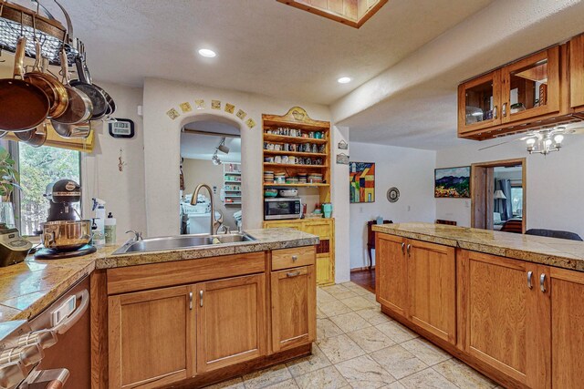 kitchen featuring stainless steel appliances, sink, and light tile floors