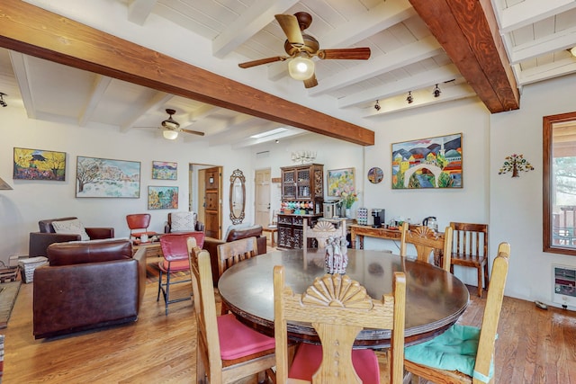 dining area with ceiling fan, beam ceiling, and hardwood / wood-style floors