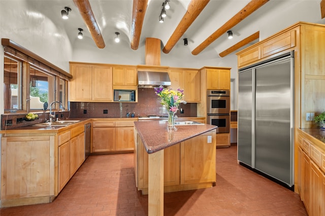 kitchen featuring a center island, built in appliances, beam ceiling, wall chimney exhaust hood, and light brown cabinets