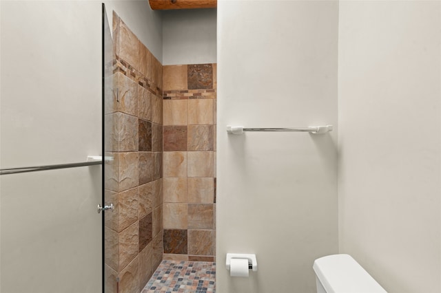 bathroom with tiled shower and toilet