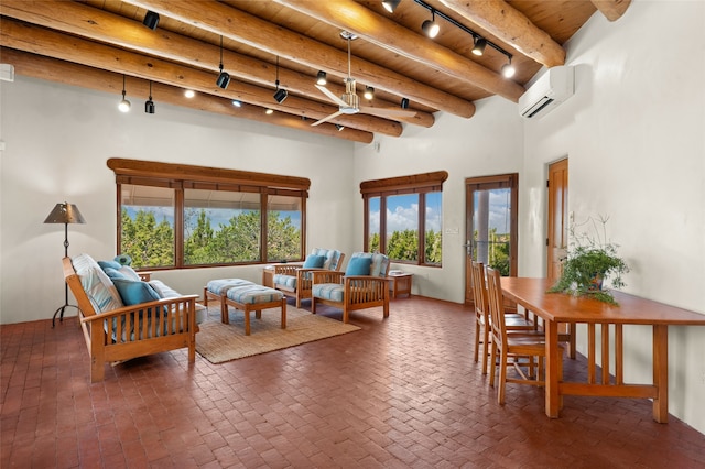 living room featuring a high ceiling, beamed ceiling, a healthy amount of sunlight, and a wall mounted AC