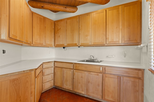 kitchen featuring sink and beamed ceiling