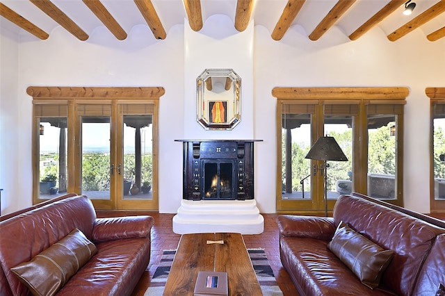 living room featuring french doors, beam ceiling, and a high ceiling