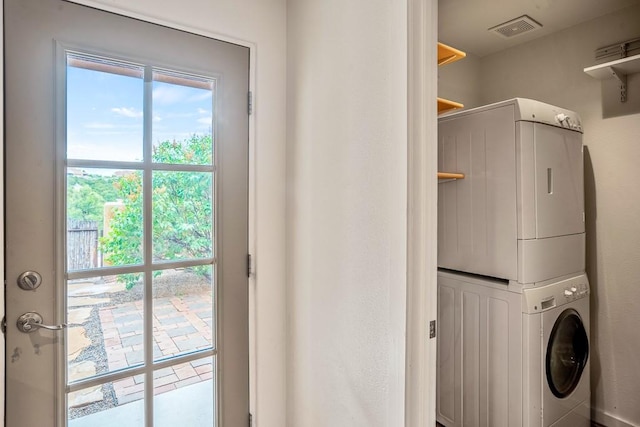 washroom with laundry area, plenty of natural light, stacked washer and clothes dryer, and visible vents