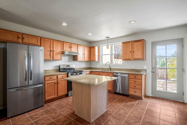 kitchen with a center island, dark tile patterned flooring, sink, decorative light fixtures, and stainless steel appliances