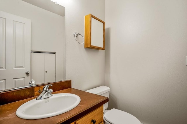 half bathroom featuring toilet and vanity