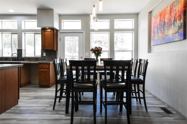 dining area with sink and light wood-type flooring