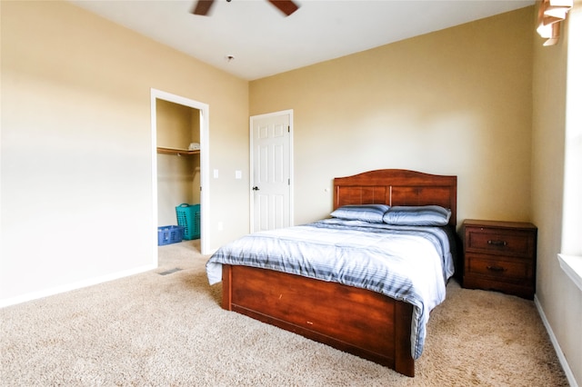 bedroom featuring carpet flooring, a walk in closet, a closet, and ceiling fan