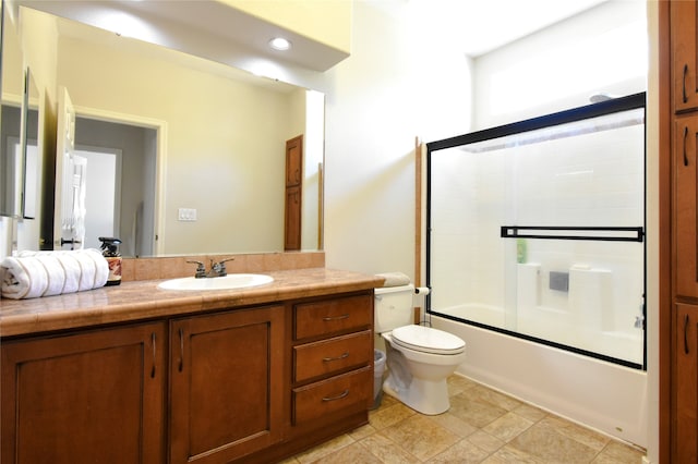 full bathroom with tile flooring, shower / bath combination with glass door, toilet, and large vanity